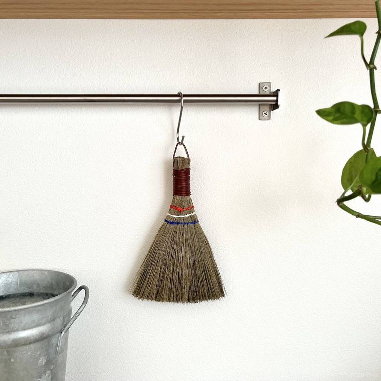 セリアのミニナチュラルほうきを吊るして収納している