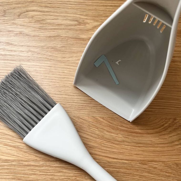 セリアのほうきちりとりセットでデスクを掃除している