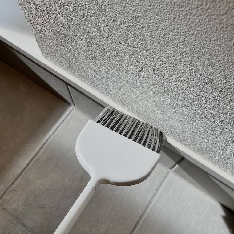 セリアのスリムほうきで巾木を掃除している