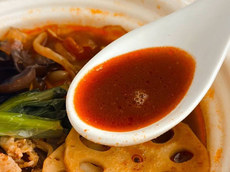 レンジで温めたセブンイレブンのつるもち太麺春雨 麻辣湯のスープをレンゲですくっている様子