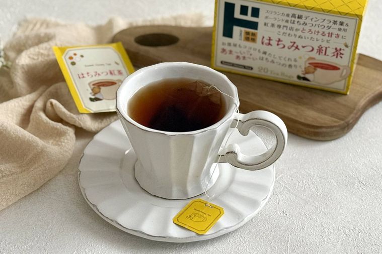 紅茶がはいった白いティーカップとはちみつ紅茶