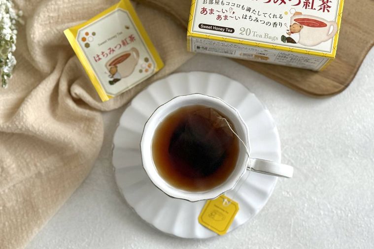 紅茶がはいった白いティーカップとはちみつ紅茶