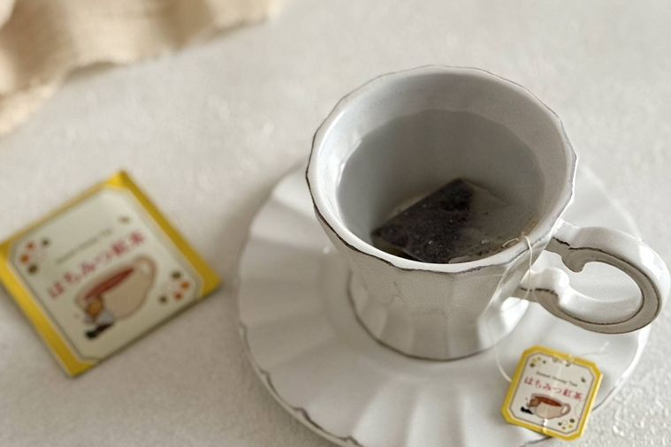 紅茶がはいった白いティーカップとドンキのはちみつ紅茶