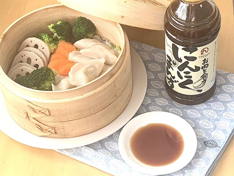 せいろで蒸した餃子や野菜に ロピアのにんにくぽんずを添えた様子