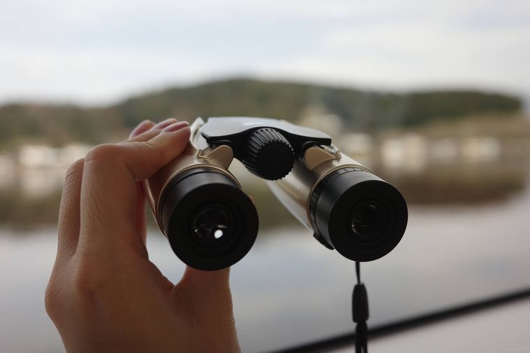 双眼鏡を手に持っている