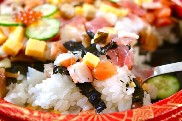 ちらし寿司を持ち上げている