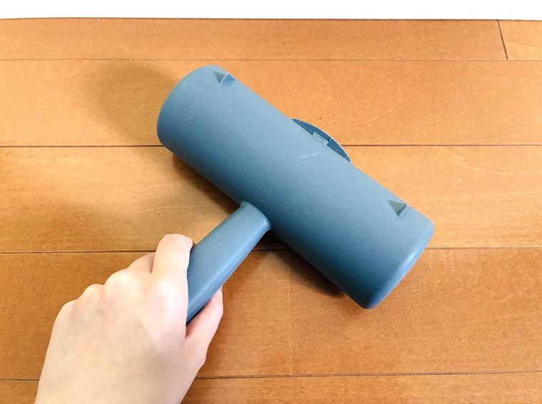 ホルダーに入ったコロコロで床を掃除している