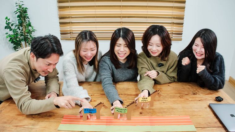 カップで作成した干支の馬を走らせる編集部メンバー