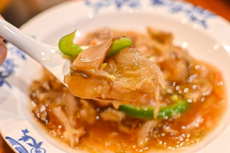 鱈のあんかけをれんげで持ち上げているところ