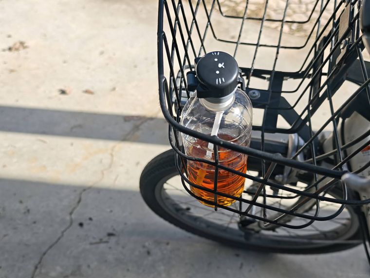 アニマル ペットボトルキャップをつけたペットボトルを自転車カゴに入れている様子