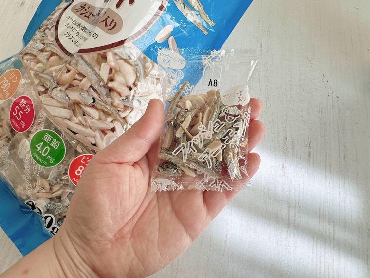 アーモンドフィッシュを手にもつ