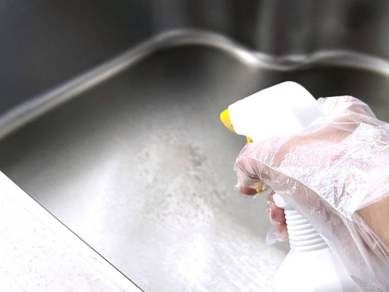 キッチンのシンクに撥水スプレーをかけている様子