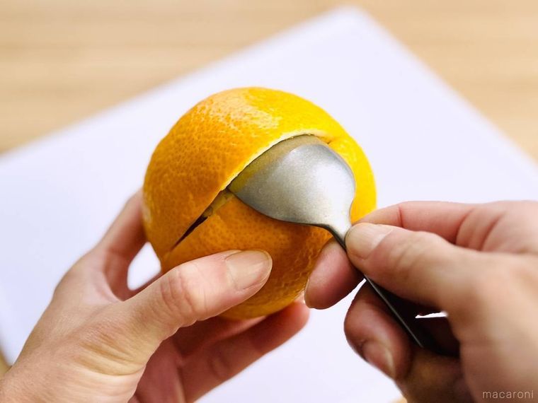 スプーンではっさくの皮と実を剥がしている様子