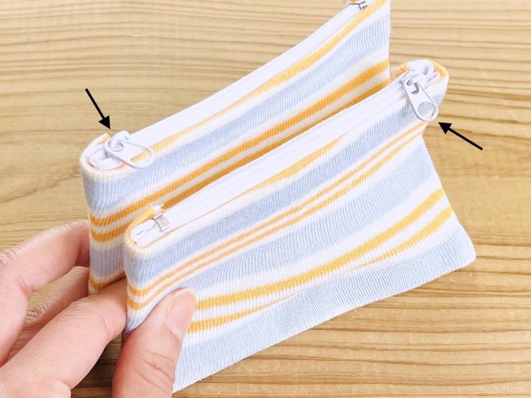 はぎれを貼ったビニールケースを2つ持っている様子