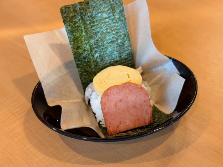 黒い器にのった海苔とご飯とスパムと玉子のおにぎり