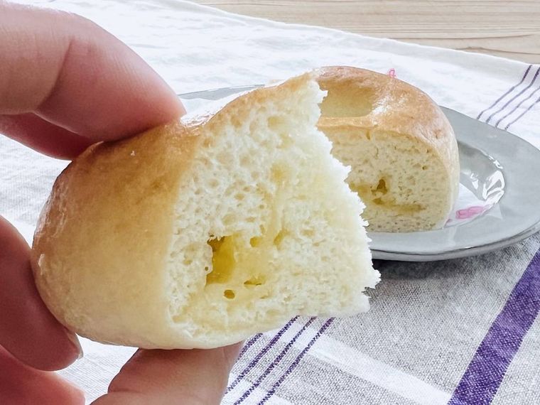 セブンイレブンのもっちり食感のチーズベーグルを手で持っている様子