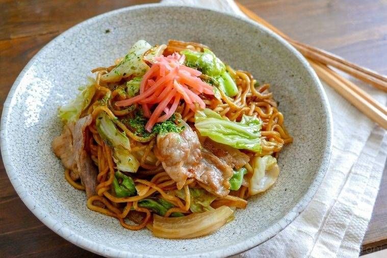 白色の皿に盛られた豚バラ肉入り焼きそば