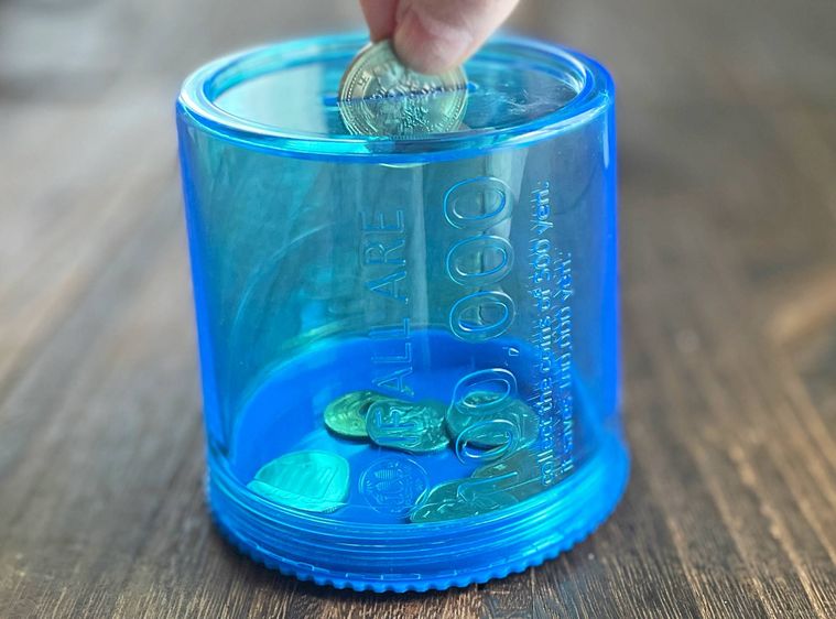 ネジ式プラバンクにコインを入れている様子