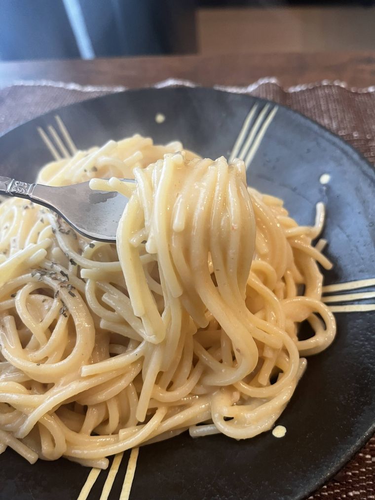 西洋料理店のかにクリームパスタをフォークで食べている様子