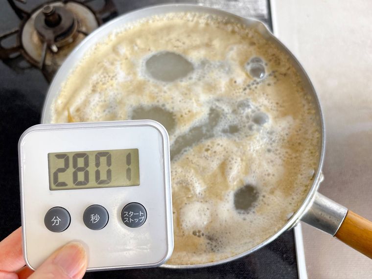 たけのこを皮付きのまま米ぬかと唐辛子を入れてゆでる様子