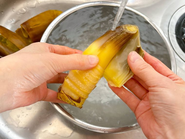 水洗いしながらたけのこの皮をむく様子