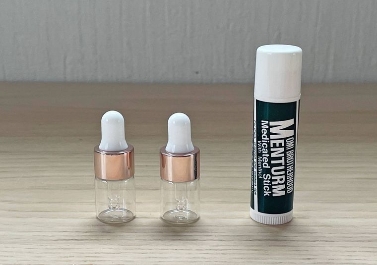 スポイト付きガラス瓶とリップを並べた写真