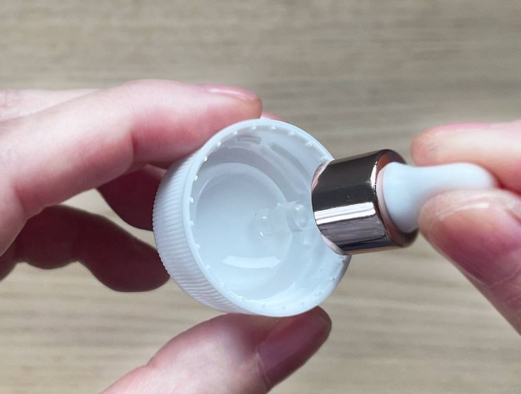 ペットボトルのフタに溜まった液体をスポイトで吸い取っている