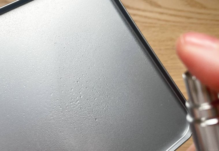 缶のフタにアトマイザーを吹き付けている様子