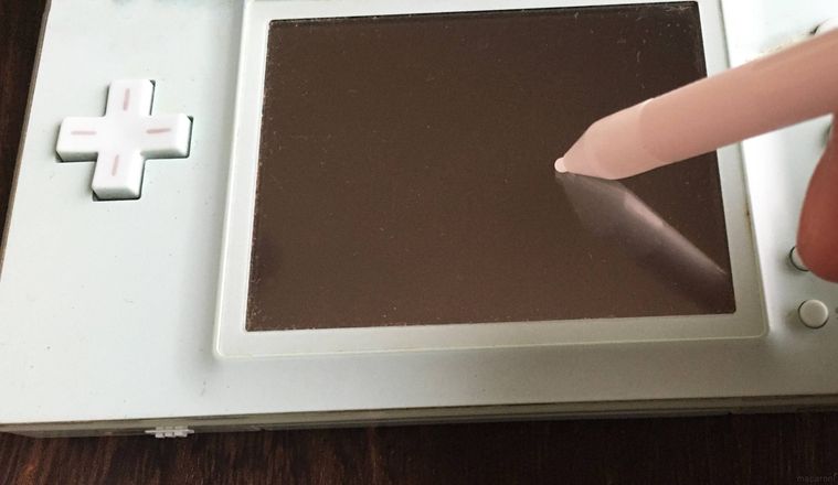 ゲーム用タッチペンでDSの画面をタッチしている