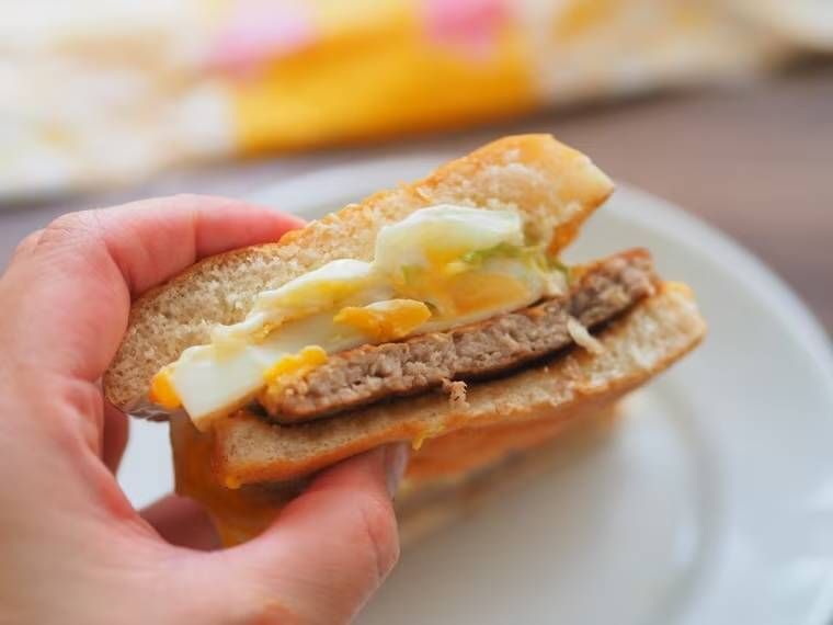 半分にカットしたチーズてりたまを手で持っている様子