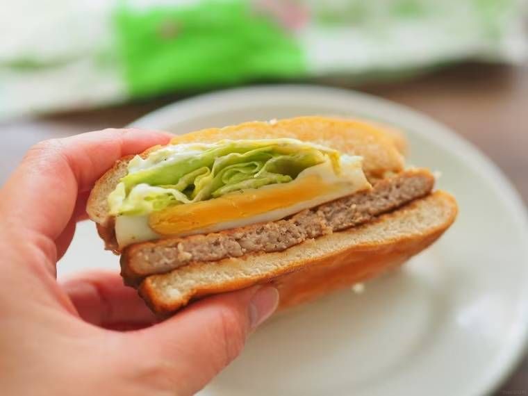 半分にカットしたてりたまバーガーを手で持っている様子