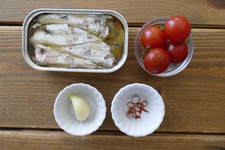 オイルサーディンのアヒージョの材料が並ぶ木製テーブル