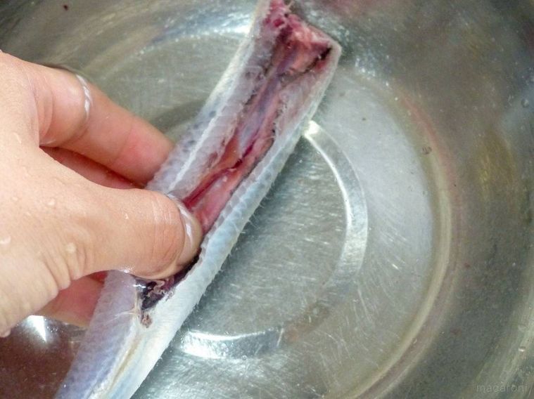いわしのはらわたを取り出して内側を水で洗う様子