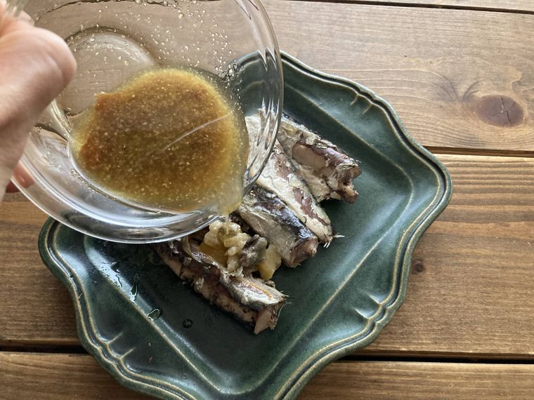 オイルサーディンにマリネ液をかける様子