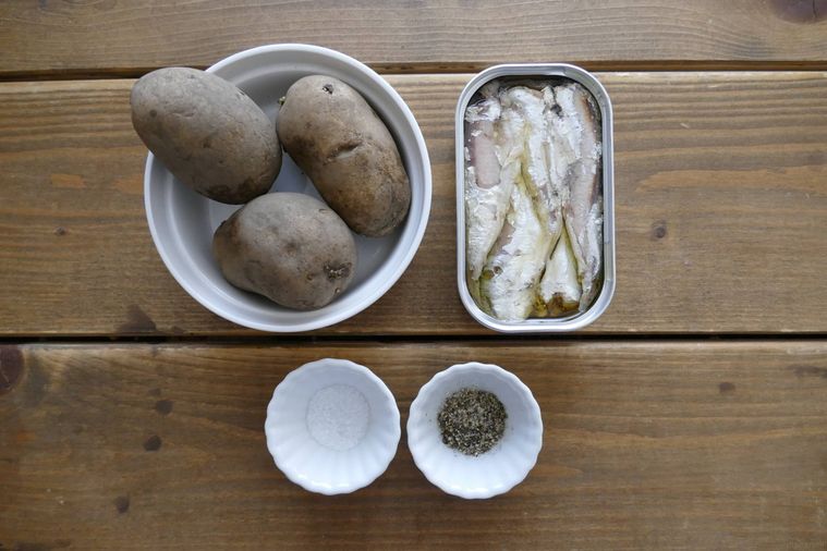 じゃがいもとオイルサーディンの炒め物の材料が並ぶ木製テーブル