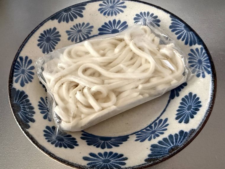 耐熱皿に冷凍うどんが乗っている