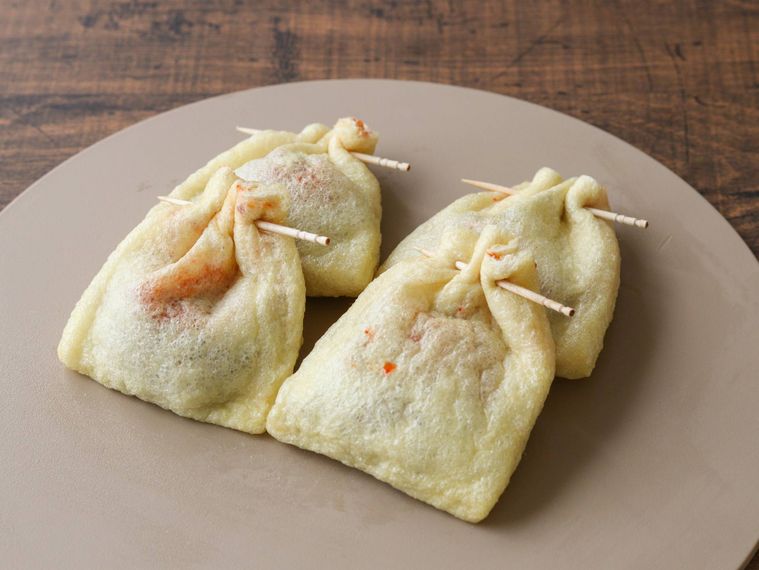 納豆と白菜キムチを詰め、爪楊枝で巾着状に口を閉じた油揚げ