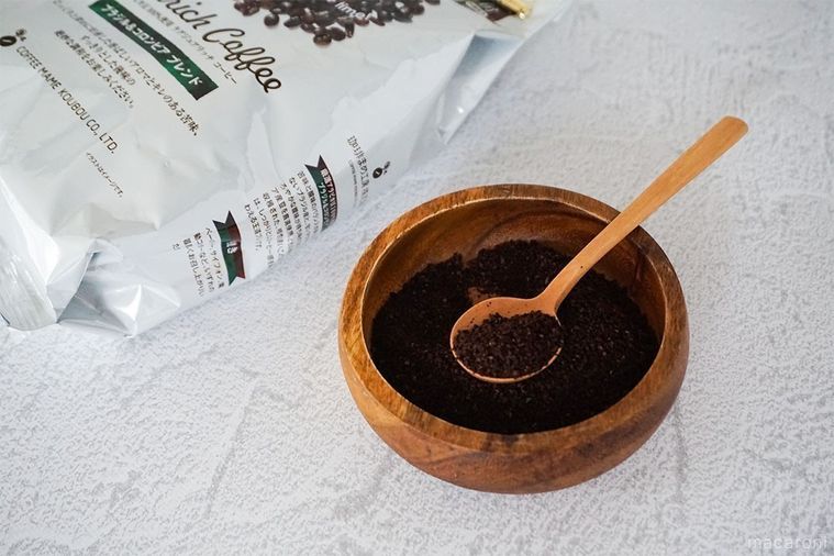 木の器に入ったラグジュアリッチコーヒーを木のスプーンですくい、奥にラグジュアリッチコーヒーの袋を添えた様子