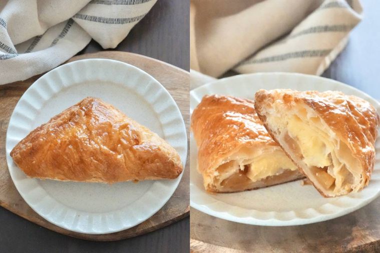 木のカッティングボードと白い皿にのった三角アップルパイ