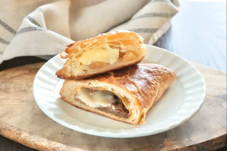 木のカッティングボードと白い皿にのったミートパイとアップルパイ