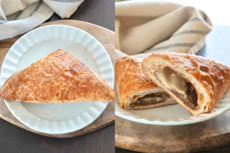 木のカッティングボードと白い皿にのった三角ミートパイ