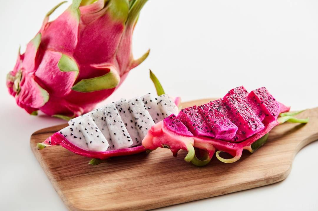 ドラゴンフルーツの赤と白が並んでカッティングボードに置かれている画像
