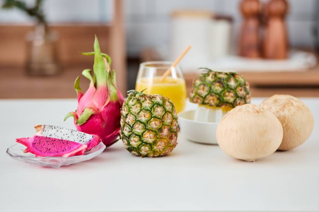 ドラゴンフルーツとパイナップルとココナッツがキッチンに置かれている画像