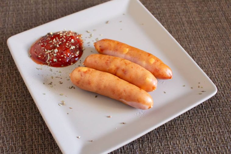 ボイルしたシャウエッセン おいちぃぃぃぃぃぃずがケチャップが盛られたお皿に盛り付けられている