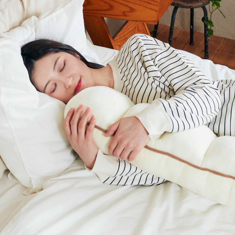 女性がふんわりちぎりパンクッションを抱えて眠っている様子