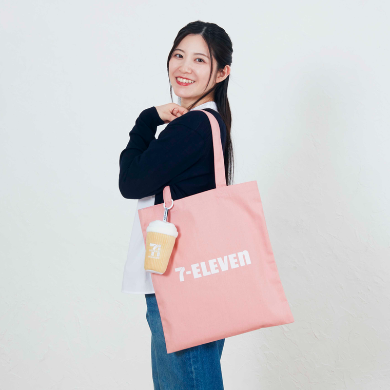 女性がピンク色のトートバッグを肩に掛けている様子