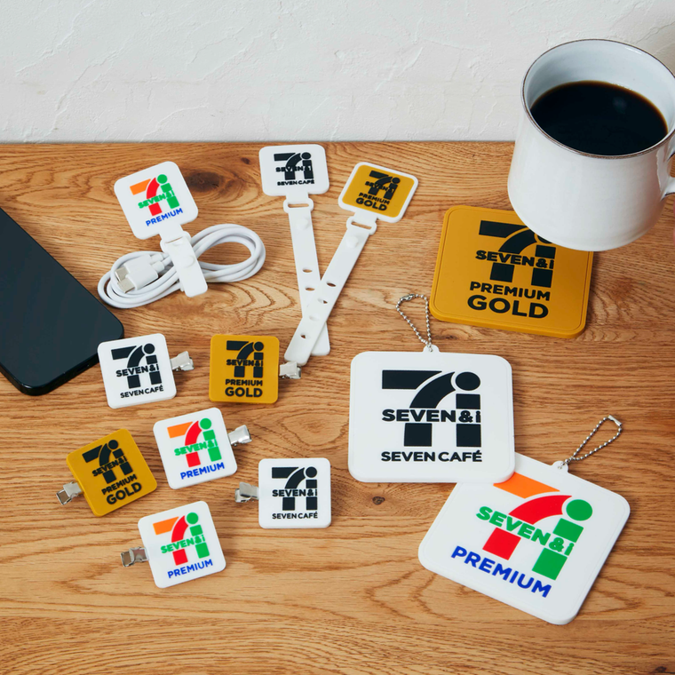 テーブルに、セブンイレブンデザインのラバーバンド、前髪クリップ、コースターが置かれている様子