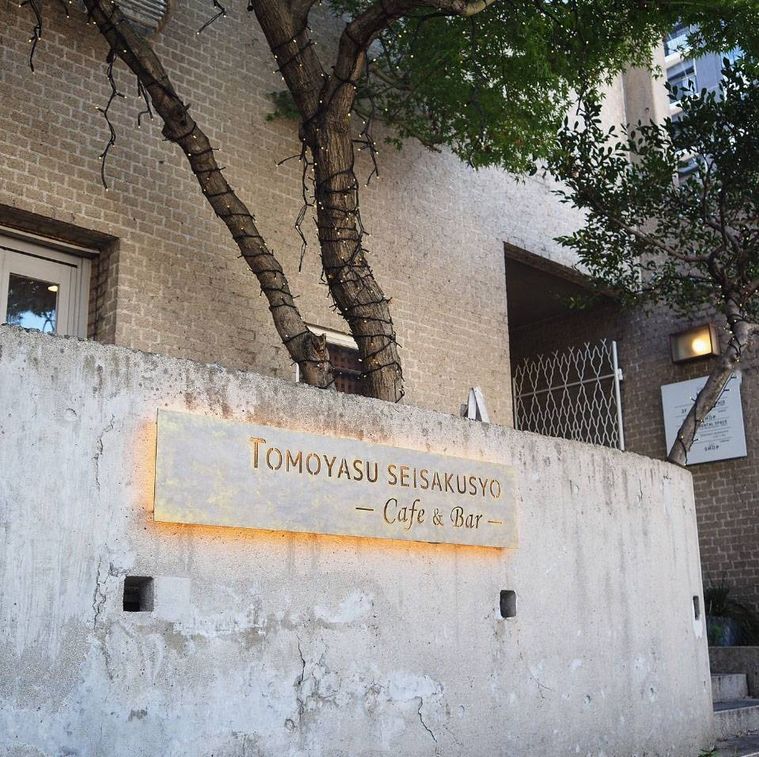 コンクリートの壁に看板がかかった友安製作所カフェバー 阿倍野の外観