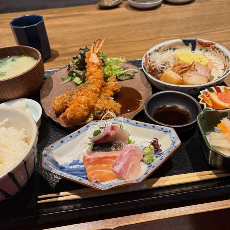 黒いお盆にのせられた大海老フライと和豚角煮定食