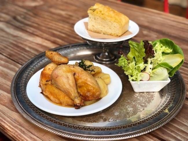 シルバーのトレーにのったローストチキンとサラダとパン